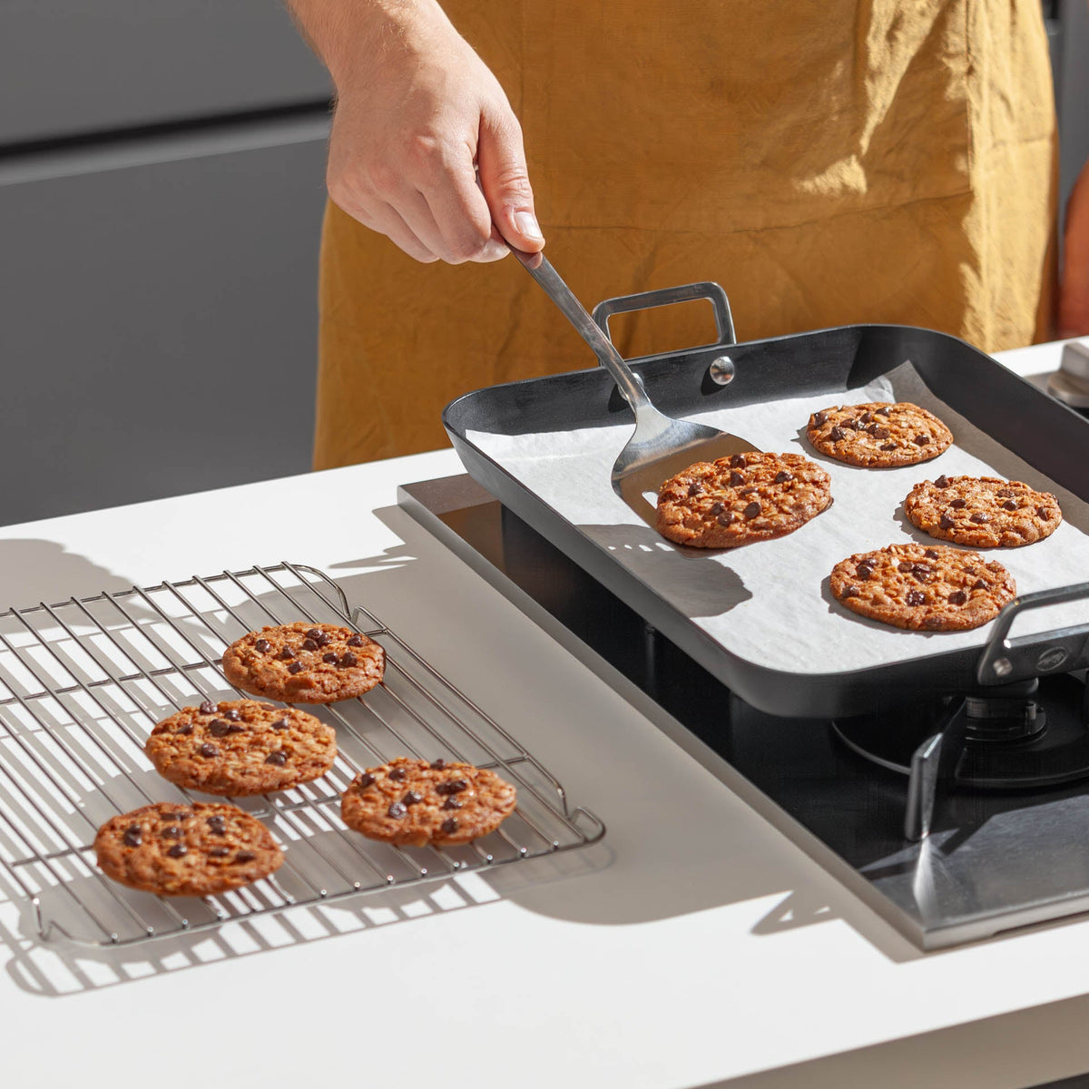 Iemand bakt koekjes op een Carbon Steel bakplaat van Bare Cookware